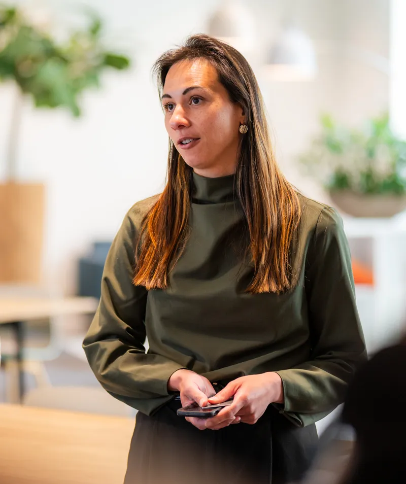A woman with an engaged posture speaking to colleagues